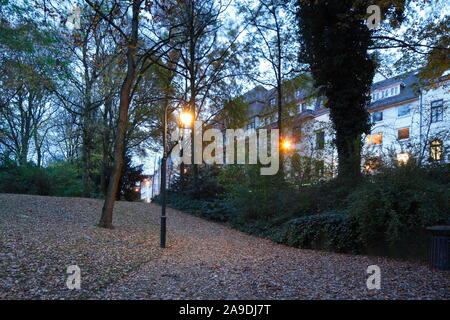 Les bâtiments résidentiels et commerciaux Strasse am Wall, arbres décolorés dans le Wallanlagen à l'automne au crépuscule, Bremen, Germany, Europe Banque D'Images