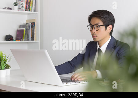 Conseiller financier asiatique ou asiatique Consulting Businessman sérieusement en face de l'ordinateur portable. Conseiller financier asiatique ou asiatique consulting businessman Banque D'Images