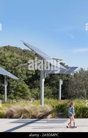 Les enfants jouent et scooters suspension réglable sur mât près de panneaux solaires dans un jardin et parc public dans les bals Chef réserver à Sydney, Australie Banque D'Images