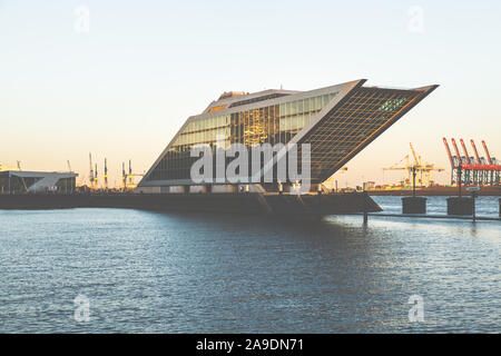 Une grande maison à Hambourg à l'Elbe dont la façade en verre brille dans le coucher du soleil Banque D'Images