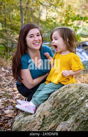 fille hurlant à la cascade avec maman toujours souriante Banque D'Images