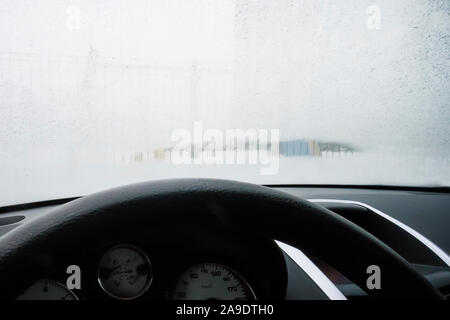 Fermer le métrage d'un pare-brise de voiture, le gel sur le pare-brise de la voiture. Vue depuis le côté conducteur. Un pare-brise de voiture congelé, dégivrage en dégivrage. Banque D'Images
