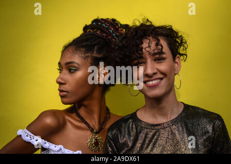 Deux jeunes femmes d'Amérique latine dans la rue ; on regarde la caméra, l'autre regarde ailleurs, Cali, Colombie Banque D'Images