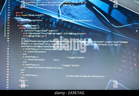 Close-up de polices et de codes sur l'écran de l'ordinateur avec l'homme de taper au clavier à l'arrière-plan Banque D'Images