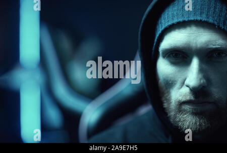 Portrait de jeune homme barbu vêtu de noir, culotte, looking at camera with serious expression Banque D'Images