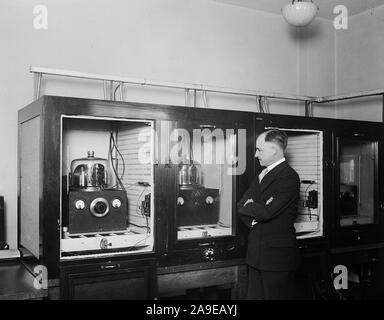 Homme avec un groupe de 100 kHz oscillateurs à cristal de quartz qui a servi comme le U.S. National fréquence primaire standard en 1929 ca. 1930 Banque D'Images