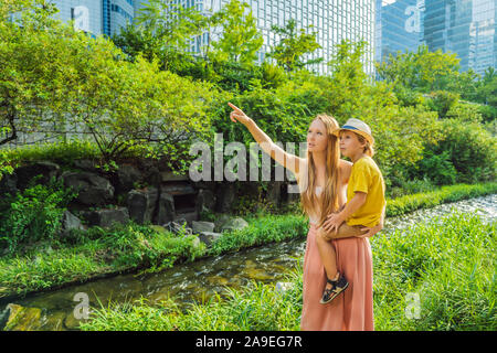 Mère et fils les touristes à Cheonggyecheon Stream à Séoul, Corée. Cheonggyecheon Stream est le résultat d'un vaste projet de renouvellement urbain. Billet à la Corée Banque D'Images