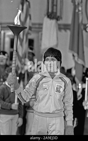 Premier porteur du flambeau olympique Sandy Norris, après son relais, s'établit à l'attention à la cérémonie d'arrivée de la flamme. La flamme, d'abord posé à Olympie, en Grèce, s'effectue dans une série de 52 relayeurs dans une course à relais de 1 000 milles de la base jusqu'à Lake Placid, New York, pour ouvrir le XIII Jeux Olympiques d'hiver. Banque D'Images