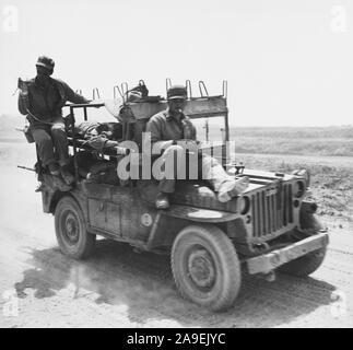 Soldat blessé à Okinawa d'être adminsitered le plasma sanguin lors d'un voyage à un poste de secours Banque D'Images