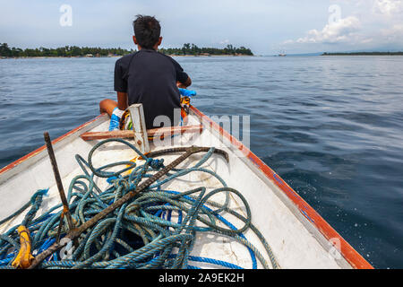 L'homme sur le bateau avec matériel de plongée et des engins de pêche dans l'île tropicale en vacances Banque D'Images