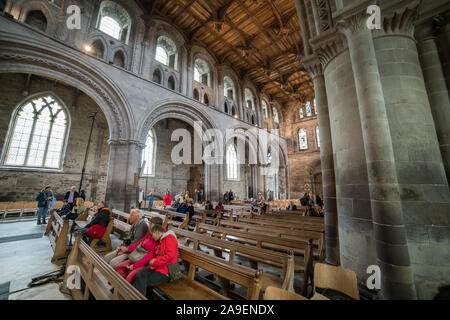 Les gens s'asseoir à l'intérieur de la cathédrale de St David's à St Davids, Pembrokshire montrant la partie principale de l'édifice historique avant un concert. Banque D'Images