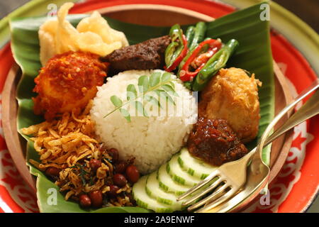 Nasi lemak Medan. Style de Medan de Malais de plat de riz riz vapeur aromatique avec un assortiment de plats de viande, oeufs, et de légumes. Banque D'Images