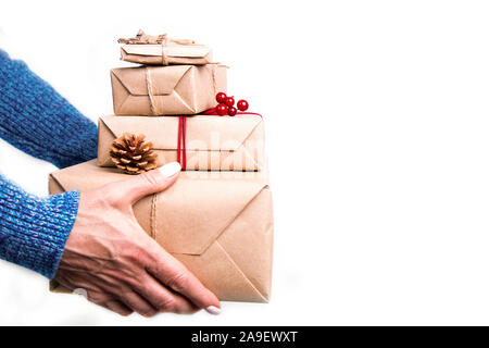 Female hands holding pile de cadeaux enveloppés dans du papier craft avec des rubans et des décorations. Image isolée. La mise en page et with copy space Banque D'Images