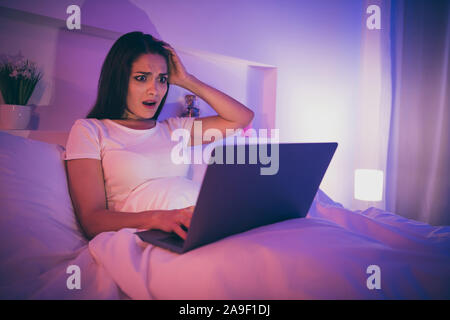 Portrait de sa charmante belle attrayante nice elle inquiète assez perplexe nerveux confondu girl Lying in Bed using laptop lecture fake news dans Banque D'Images