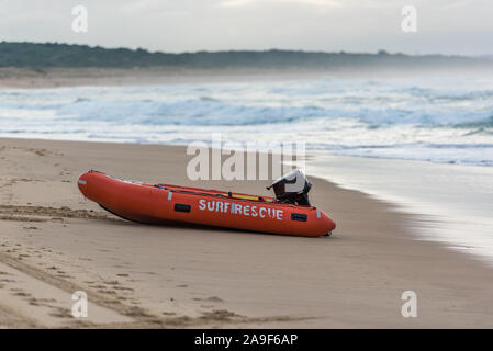 Surf orange vif saver bateau sur une plage de sable rive. Cronulla, Australie Banque D'Images