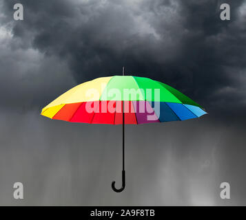 Parapluie colorés en face de ciel nuageux Banque D'Images