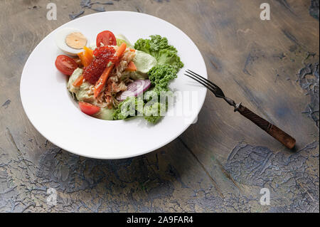 Salade à la viande de crabe, avocat, des légumes frais et du caviar de saumon sur une plaque blanche. Plan horizontal Banque D'Images