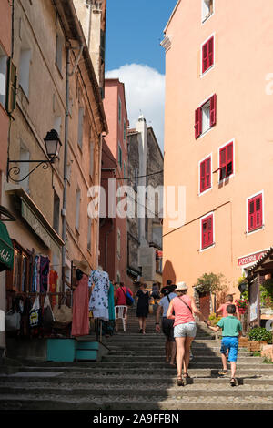 Les touristes jusqu'à l'épaulement étroit rue commerçante rue Scoliscia dans la vieille ville de Corte dans le centre corse, Haute-Corse, France Europe. Banque D'Images