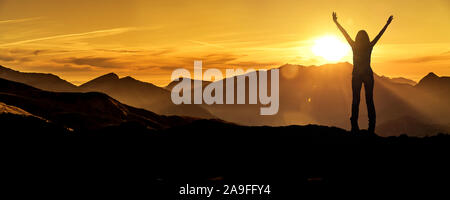 Femme dans la victoire posent au lever du soleil sur un sommet de montagne Banque D'Images