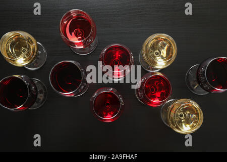 Mise à plat. Lunettes avec différents vins sur fond sombre, copy space Banque D'Images
