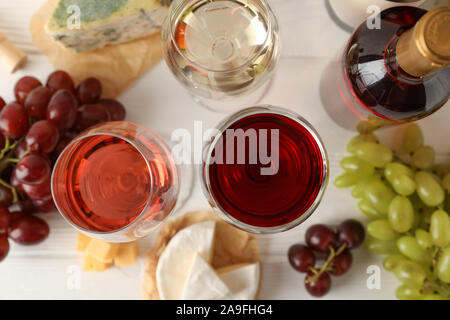 Raisin, fromage, bouteille et verres de vin sur fond blanc, vue du dessus Banque D'Images