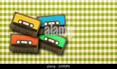 Des cassettes de musique ancienne en différentes couleurs sur une nappe à carreaux Banque D'Images