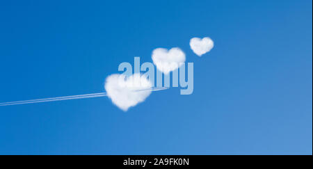 Avion vole dans un nuage en forme de coeur Banque D'Images