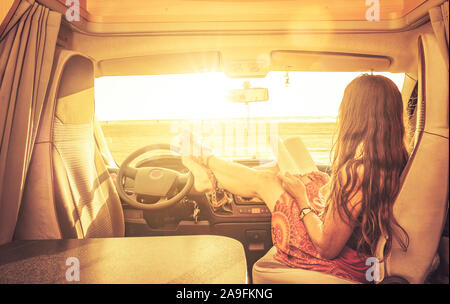 Femme avec livre dans un camping-car Banque D'Images