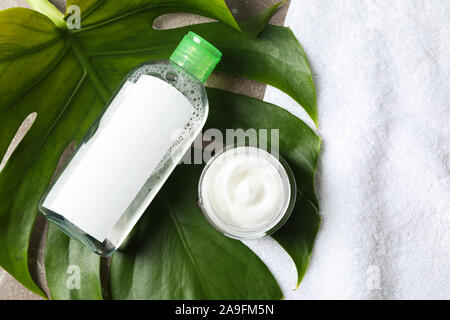 La feuille de palmier, crème, savon et shampoing sur fond gris, vue d'en haut Banque D'Images