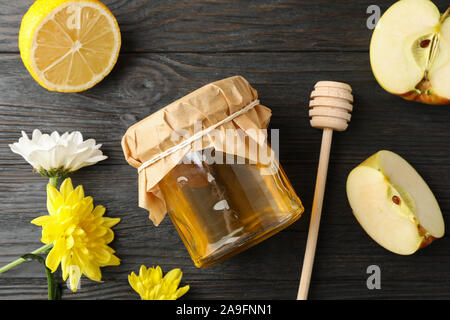 Balancier, pomme, citron, fleurs et pot de miel sur fond de bois, vue du dessus Banque D'Images