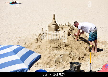 L'homme et château de sable à la plage de Silgar. Sanxenxo, Rias Baixas, l'Espagne. Le 12 mai 2019. Banque D'Images