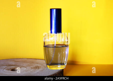 Flacon de parfum bleu sur un fond jaune et un coffre. Notion de bonne odeur. Banque D'Images