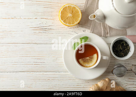 Tasse de thé au citron, menthe, tamis, le gingembre et une théière sur fond de bois, vue du dessus Banque D'Images