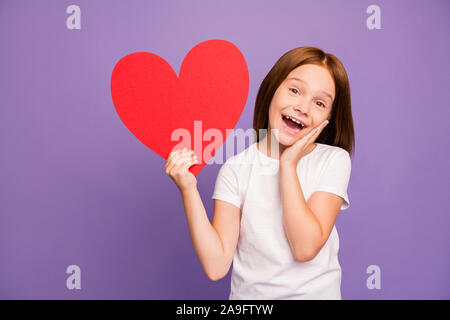 Photo de joie assez peu Foxy Lady tenir de grandes papier rouge coeur figure camarade garçon fait maison de vacances présent surprise porter t-shirt blanc isolé Banque D'Images