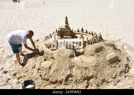 L'homme et château de sable à la plage de Silgar. Sanxenxo, Rias Baixas, l'Espagne. Le 12 mai 2019. Banque D'Images