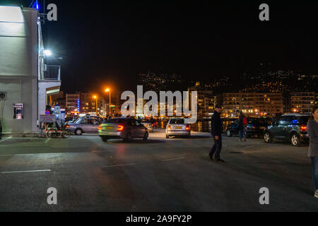 Le trafic de nuit avec les gens et les voyageurs qui quittent le port de Volos et hôtel de ville, Thessalie, Grèce Banque D'Images