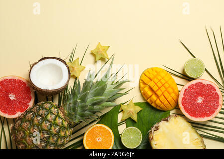 Fruits exotiques et de feuilles de palmier sur fond beige, de l'espace pour le texte Banque D'Images