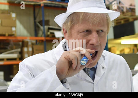 Premier ministre Boris Johnson mange certains rock lors d'une visite à la Sucrerie de couronnement à Blackpool tandis que la campagne électorale générale. Banque D'Images