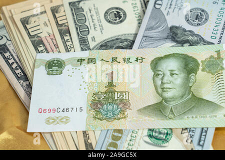 L'argent en Chine CNY, payer de l'argent change, République populaire de Chine (RPC) yuan et de l'argent à l'US dollar USD, payer, sur fond jaune. Banque D'Images