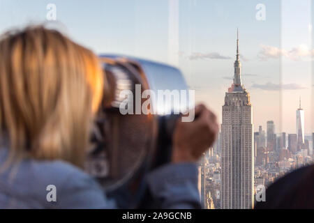 New York, USA - 17 mai 2019 : Rear View of Woman Peering Through Viseur Binoculaire à New York du Haut de la roche Banque D'Images