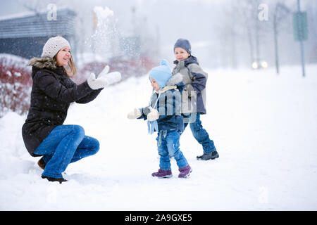 Finnland, Mutter und 2 Kinder bei Schneeballschlacht, Banque D'Images