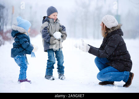 Finnland, Mutter und 2 Kinder bei Schneeballschlacht, Banque D'Images