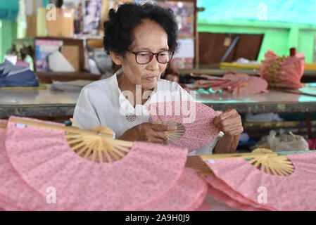 Vieille dame thaïlandaise faire part des supporters à Bo Sang près de Chiang Mai, Thaïlande Banque D'Images