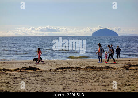 Les gens qui marchent sur la plage à Girvan Ayrshire, Ecosse du Sud avec l'Ailsa Craig dans la distance. Banque D'Images