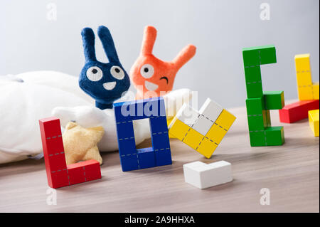 Puzzle en bois coloré jouet en bois, blocs de construction avec des formes géométriques. Le mot amour Banque D'Images
