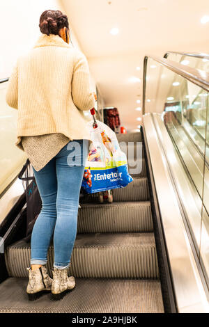 Les gens utilisent les escaliers roulants au moment de Noël dans le magasin Primark, boutique, shopping et aller d'un étage à l'autre Banque D'Images