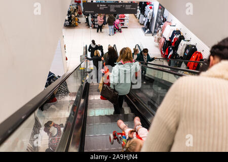 Les gens utilisent les escaliers roulants au moment de Noël dans le magasin Primark, boutique, shopping et aller d'un étage à l'autre Banque D'Images