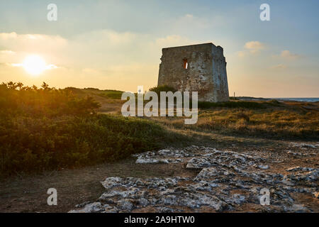 Ruines d'une antique Torre Pozzelle Guet côtière dans un coucher de soleil colorés Ostuni Puglia Italie. Banque D'Images