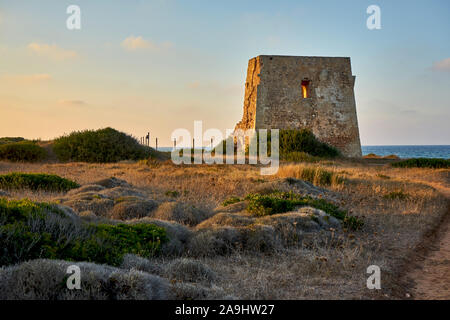 Ruines d'une antique Torre Pozzelle Guet côtière dans un coucher de soleil colorés Ostuni Puglia Italie. Banque D'Images