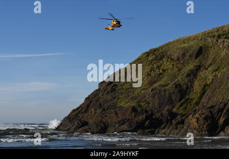 Un équipage de la Garde côtière à bord d'un hélicoptère MH-60 Jayhawk procède à la formation de sauvetage en falaise dans le cadre de l'école de sauvetage hélicoptère avancé près de North Head, le 13 novembre 2019, à Fez, Washington. L'École de sauvetage hélicoptère avancé d'environ 120 trains aviators de partout au pays chaque année dans les techniques de sauvetage. (U.S. Photo de la Garde côtière canadienne par le maître de 3e classe Trevor Lilburn) Banque D'Images